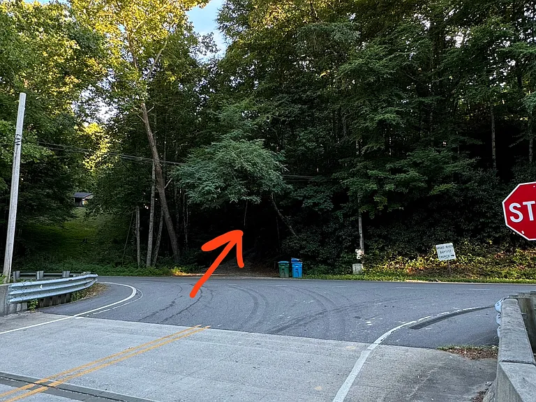 Driveway is directly across from the stop sign on the bridge.