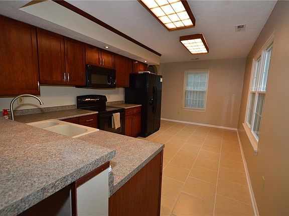 Eat in kitchen with warm cherry cabinetry. Newer appliances included.