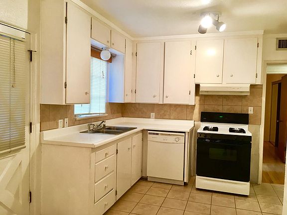 Kitchen displaying stove/oven/fan and dishwasher. 