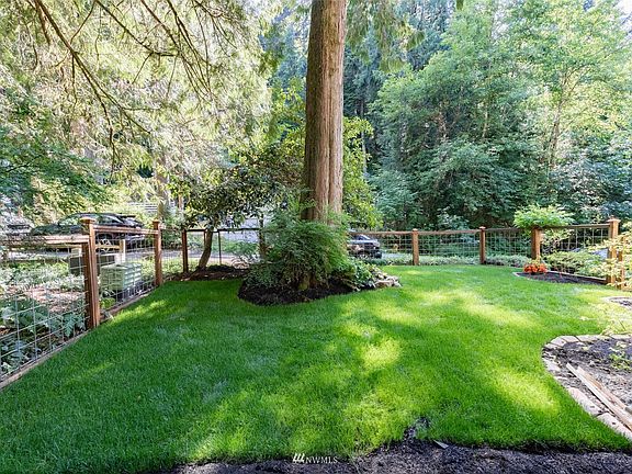 Lush grass and gates to driveway and back yard.>