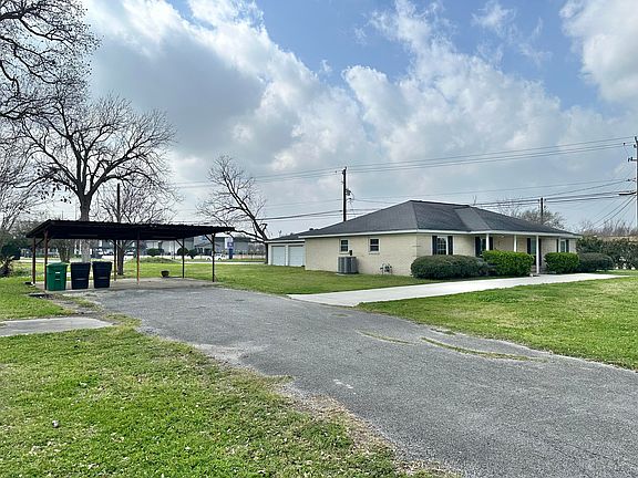 Expansive driveway with additional pull-out by the front door. Two-car carport.
