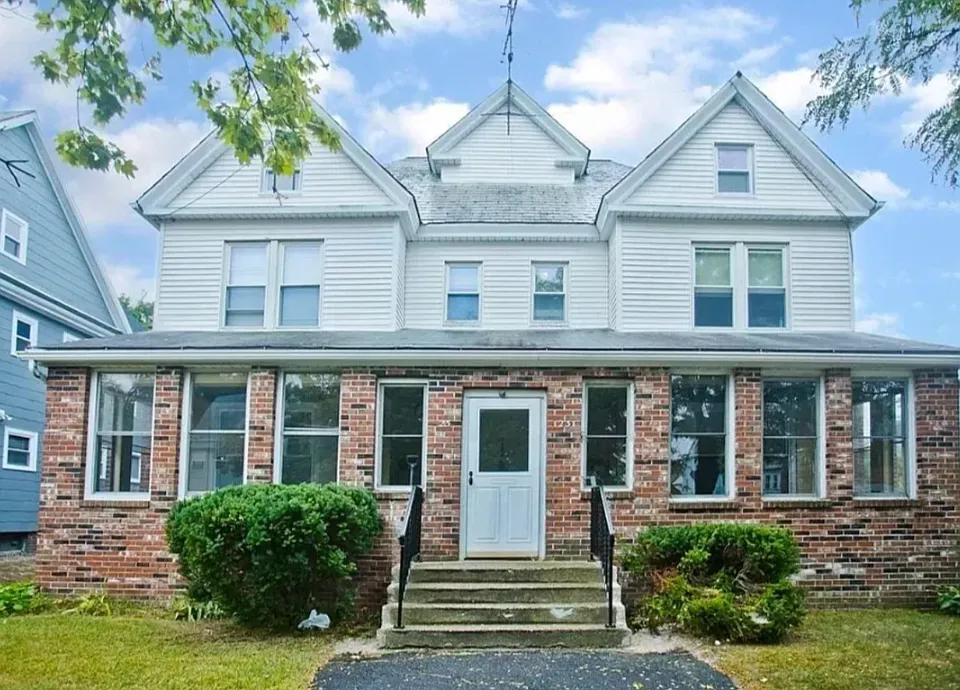View of house from street; door opens to enclosed front porch. Your unit is on the left side.