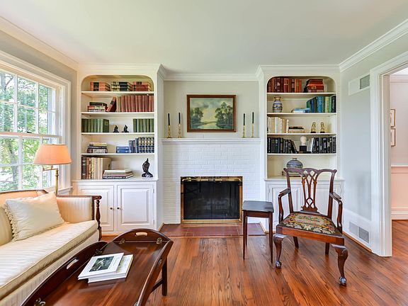 Gracious living room with built in bookshelves, crown molding and a fireplace