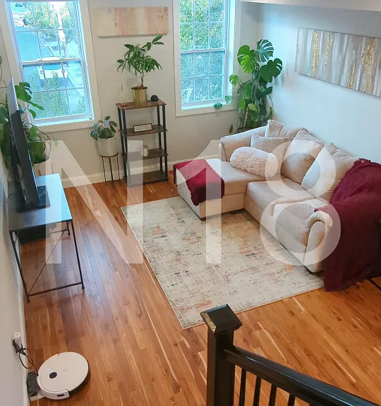 Living room on main level with plenty of natural light and blackout electric blinds