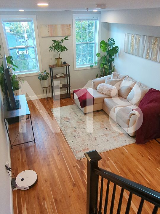 Living room on main level with plenty of natural light and blackout electric blinds