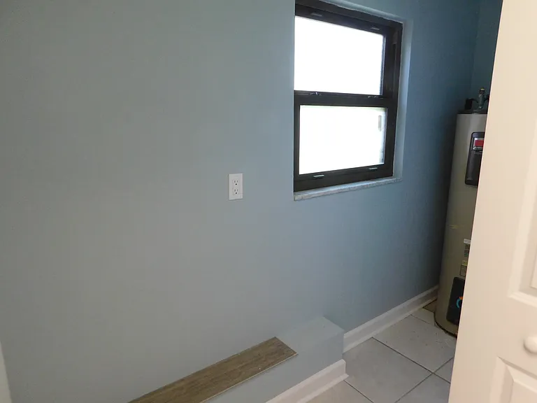 Just past the laundry area is a small utility room where the full-sized water heater is located. Entry is via bi-fold doors.