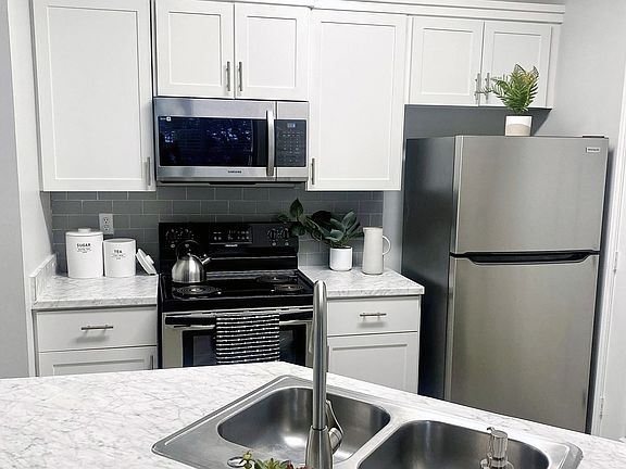 White cabinetry and stainless-steel appliances in our open-concept kitchens are complimented by Carrara marble inspired countertops in select homes.