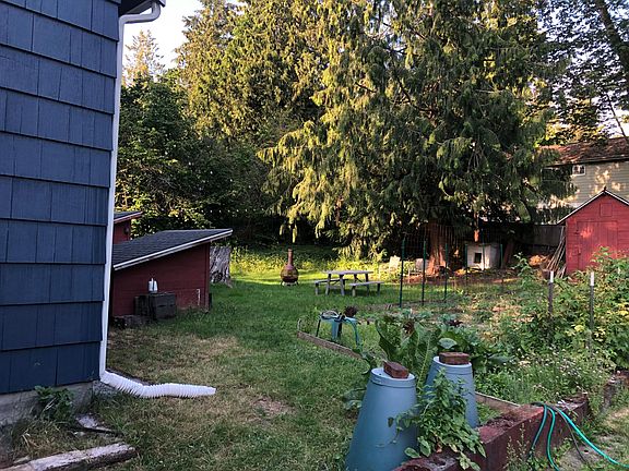 Spacious backyard with fire pit, picnic table and shared vegetable garden