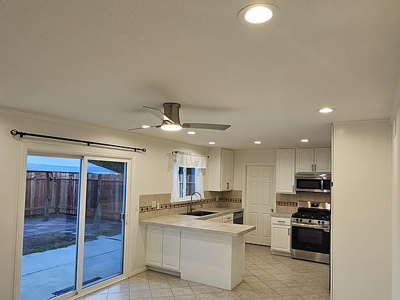 Slider leads to back yard and back garage entry door. Concrete patio with plenty of room for BBQ/Patio table/chairs. Trash cans stored on side yard area which also has storage area for bikes, surf / SUP boards, etc.