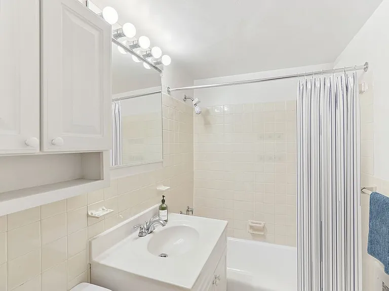 Bath with white cabinetry, white laminate countertops, and hard surface flooring