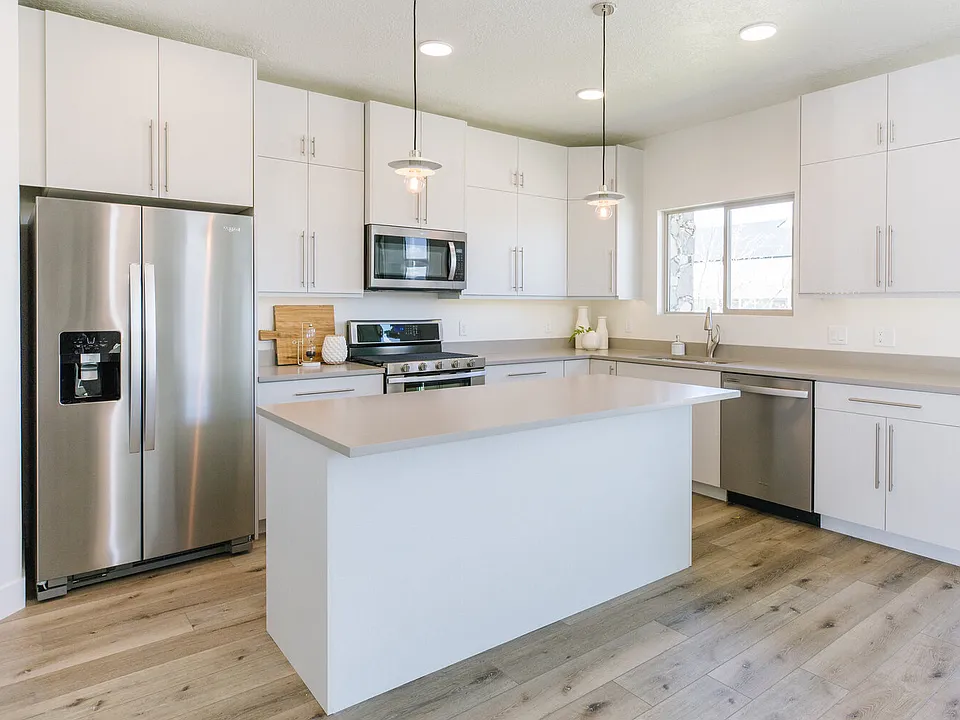 Kitchen is bright and open to the living room with stainless steel appliances and pantry.