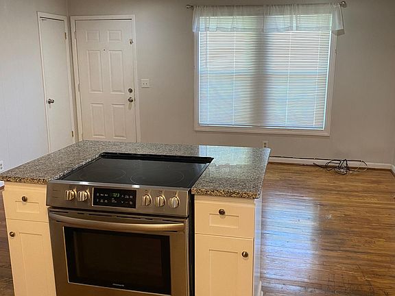 Gorgeous hardwood floors and accent beam in this open concept living room/kitchen