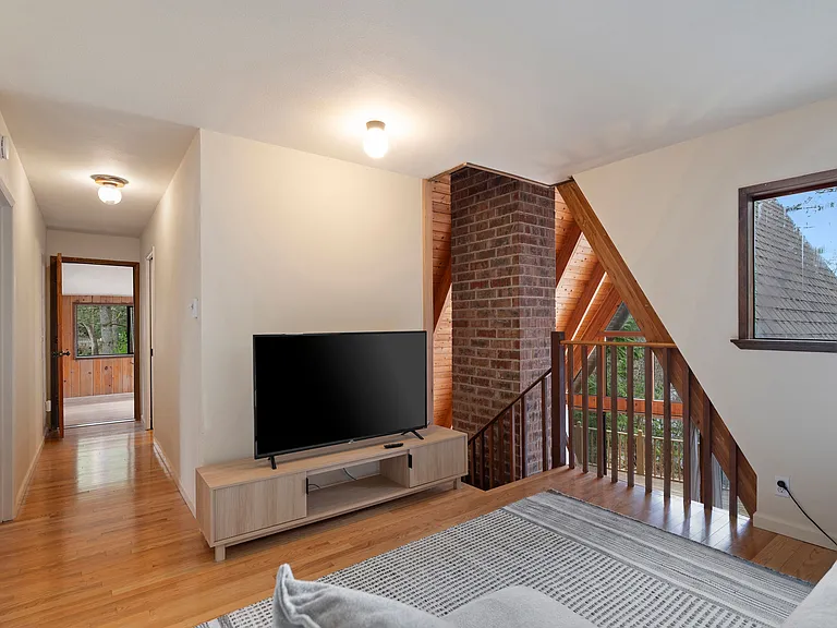 One smart Roku equipped television is provided in the loft with a large sofa for four.