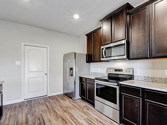 Enjoy stunning granite countertops and designer wood cabinetry in this kitchen.