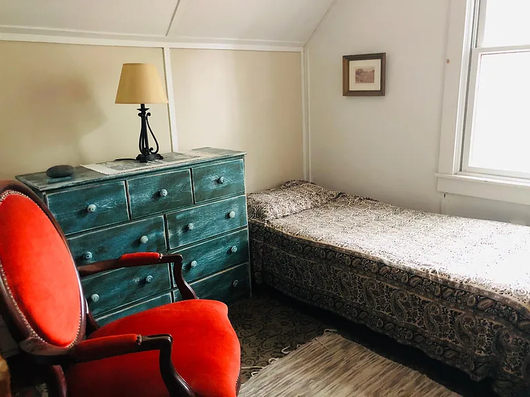 Second floor single bedroom with dresser and antique chair