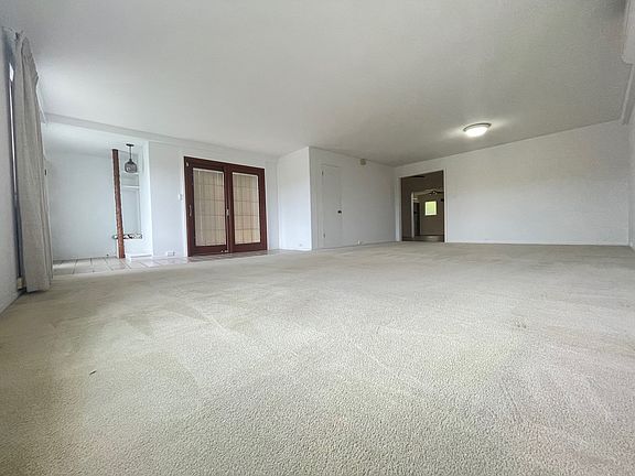 Living area facing entrance, side patio, closet and kitchen