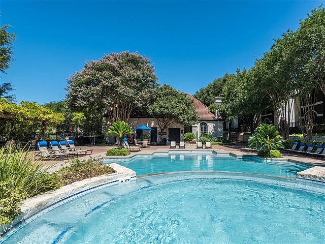 Pool surrounded by lush landscape and poolside seating