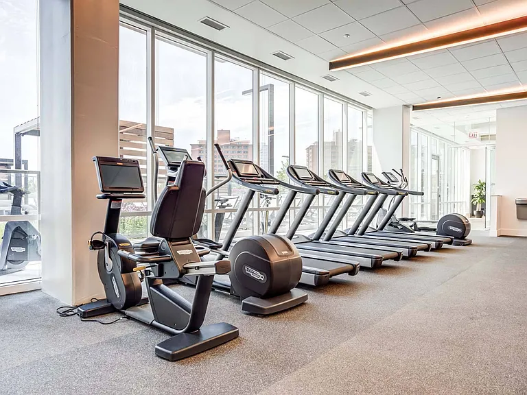 Push your limits with a row of treadmills and ellipticals, offering an energizing workout experience in a bright, open space.