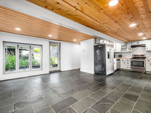 open concept floor plan with slate tile floors and bead board ceilings