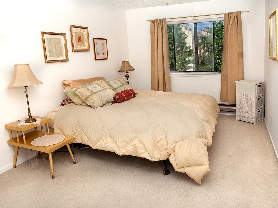 Main upstairs bedroom facing out onto garden, trees and grass, in the back