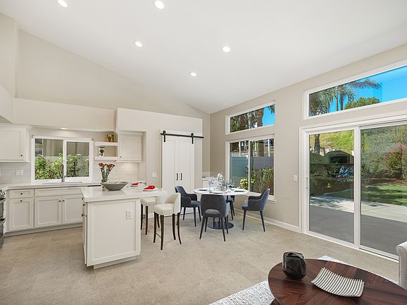 Open kitchen with bar area and eating area. With quartz countertops and subway tiles forl backsplash.