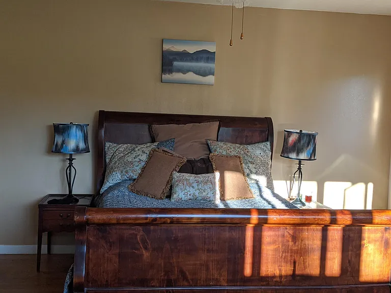 Sleigh master bedroom bed drenched in early morning sun