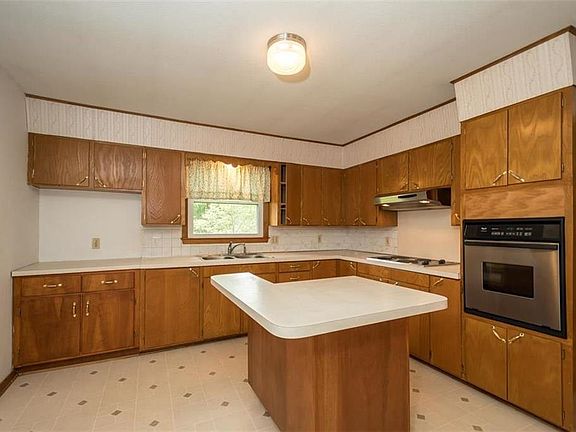 Enter the kitchen from the garage.  Built in Stove with over head vent and built in oven. The cabinets to the left could be removed to put the fridge in that location again.