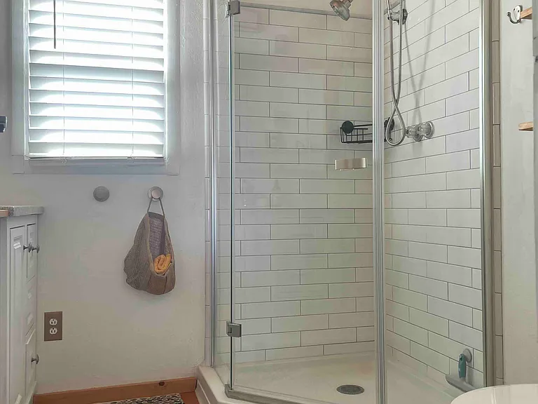 Bathroom with standup shower and planked ceiling.