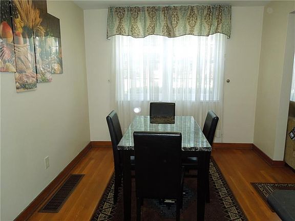 Dining room with refinished HW floors and includes table and chairs and wall fixture
