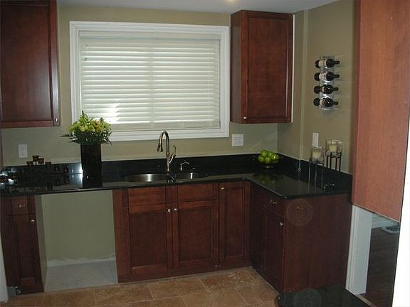 black granite countertops, cherry cabinets and Noce travertine flooring