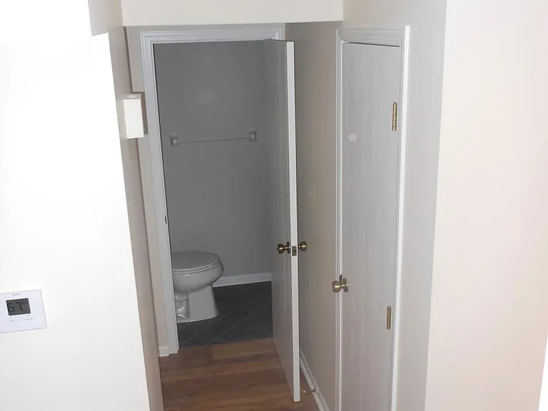 Hallway connects garage to living area. Half bath and coat closet.