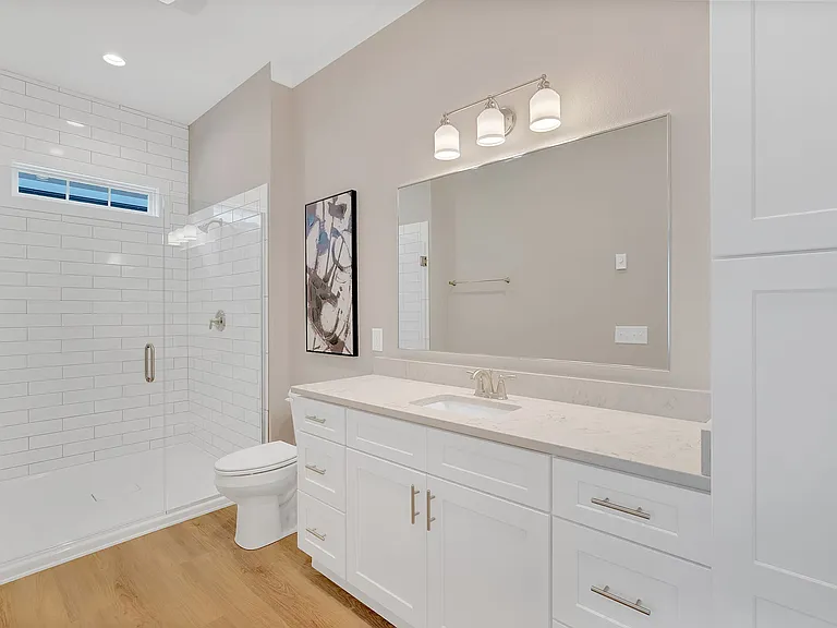 Tiled walk-in shower and double vanity with storage