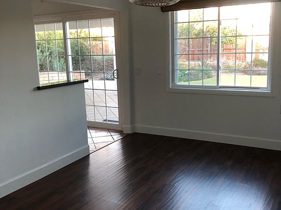 View of dining room with window leading to yard and counter in kitchen to the left.