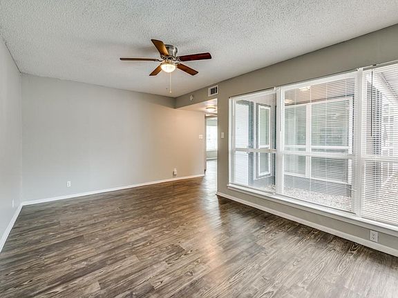 Unfurnished room with a textured ceiling, wood finished floors, and ceiling fan