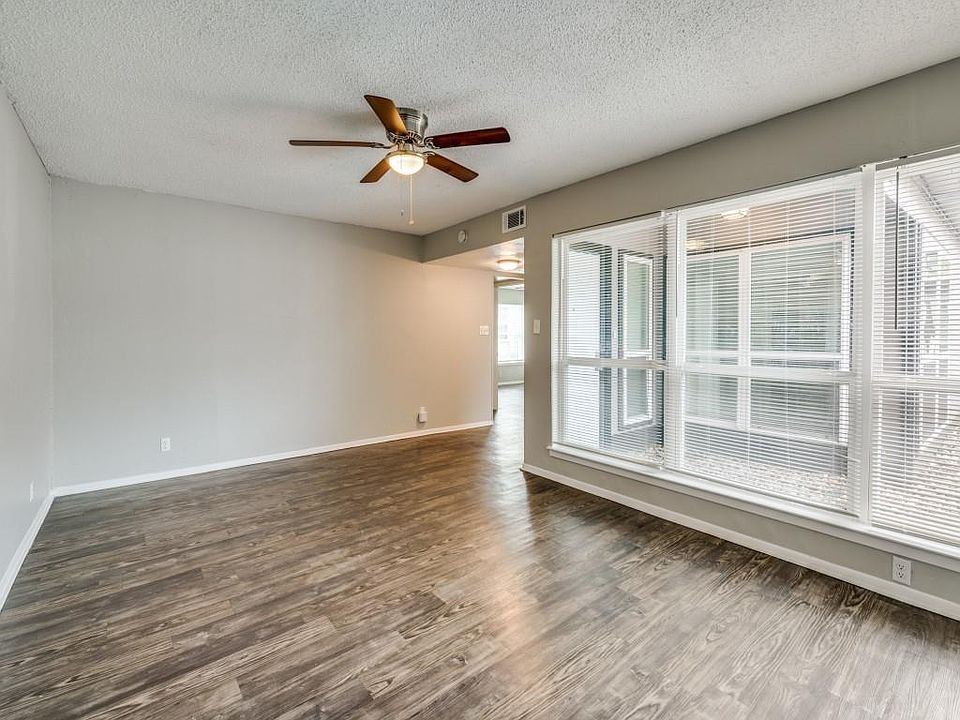 Unfurnished room with a textured ceiling, wood finished floors, and ceiling fan