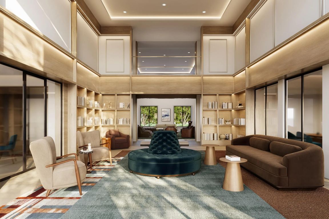 The clubroom features double-height ceilings, curated lounge seating, built-in library shelving, private meeting spaces, and sophisticated design elements that create a welcoming environment for gathering, working, and relaxing.