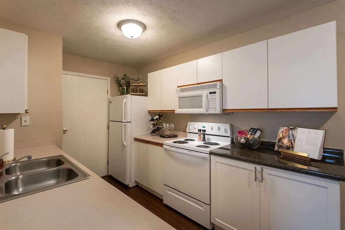 Our model Liberty kitchen features both upgraded cabinetry with dark countertops and classic cabinetry with light countertops. - Washington Place