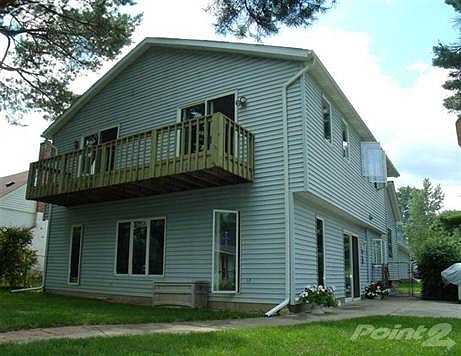 View of home, balcony, and patio from the lake.