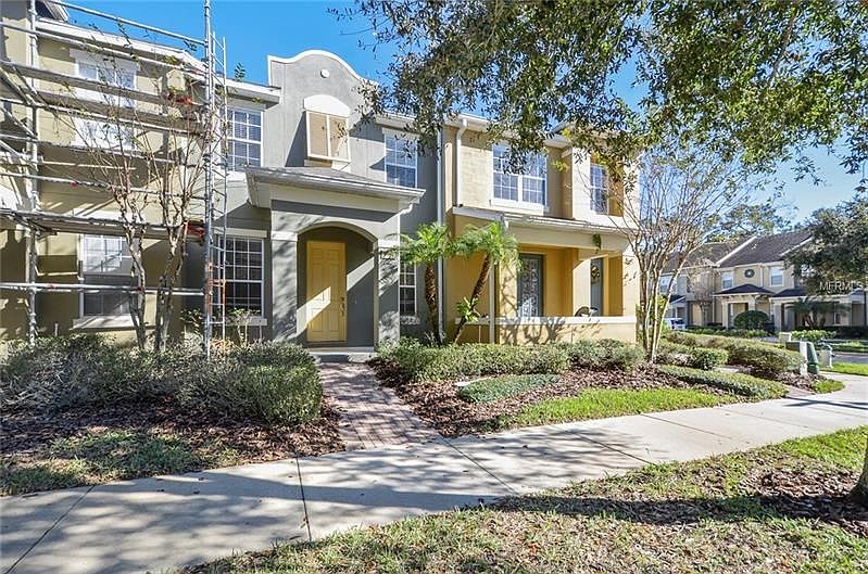 7719 Anselmo Lane - Welcoming Entry with "Sunny Florida" yellow door (Scaffolding is for Townhome to left).