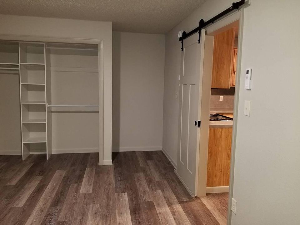 Bedroom with barn door to kitchen on right