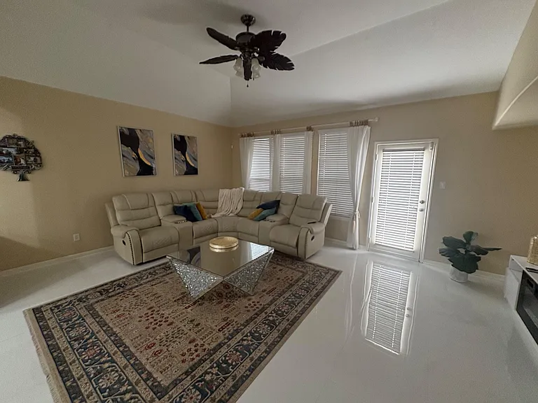 Spacious living room with a large sectional, Smart TV and electric fireplace.