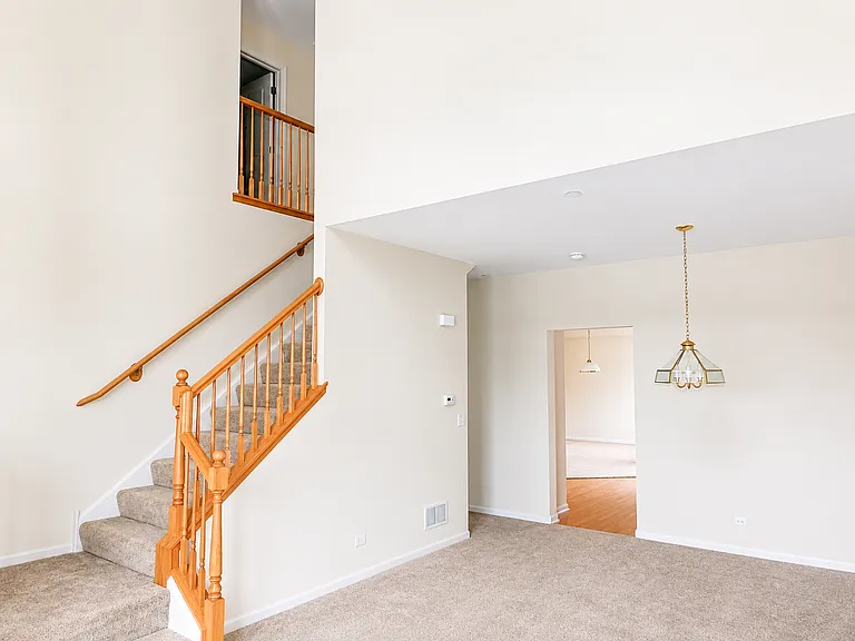 Living and dining area with a staircase leading to the second floor and a doorway to the kitchen. To the left of the kitchen doorway, add a hallway leading to the master suite and the staircase to the basement.
