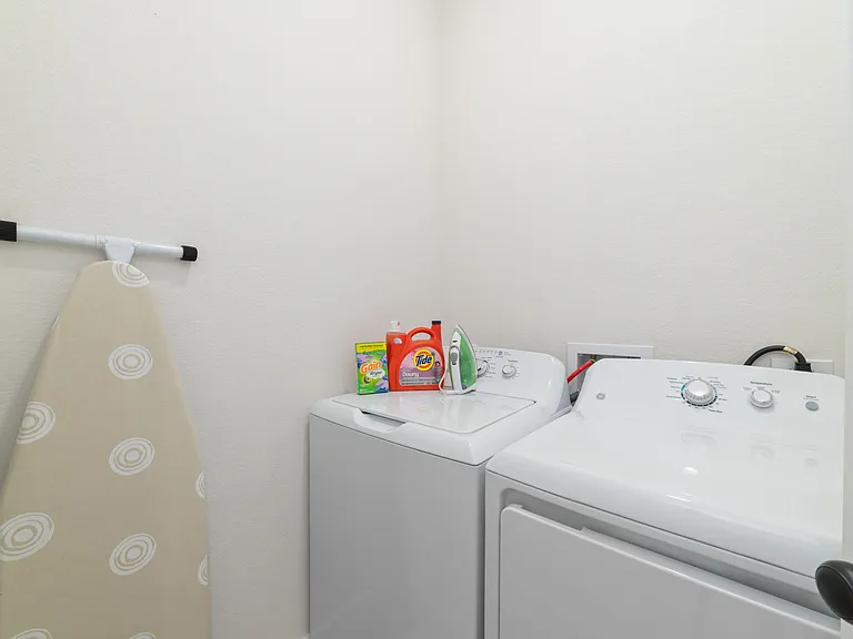 Laundry room with Detergent, Full size ironing board and Iron.