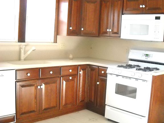 Newer Eat in Kitchen with Corian Countertop and Maple Cabinets