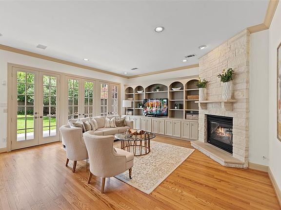 View from the archway of the living room, great space for entertaining! Beautiful built-ins and limestone gas fireplace.