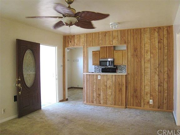 Spacious Living Room Features Ceiling Fan Decorative Front Door and Pass Thru to the Kitchen.