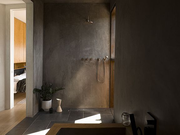Wet room features imported hand-made Moroccan brass faucets and a custom 6 foot concrete soaker tub