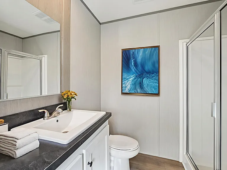 The ensuite bathroom features a walk-in shower and clean, modern finishes.