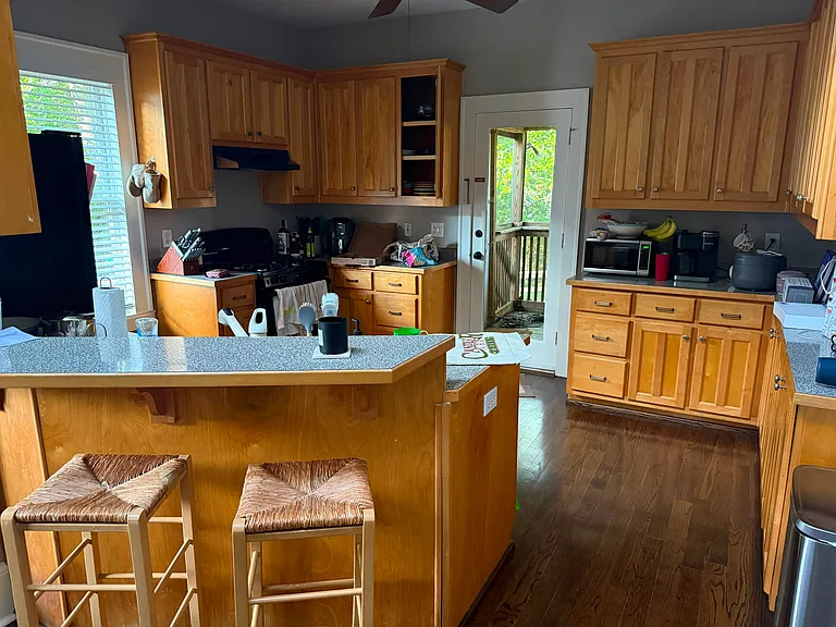 kitchen with bar to dining living area. Lots of storage and decent counter top areas. Garbage disposal, dishwasher and black stove/oven and refrigerator