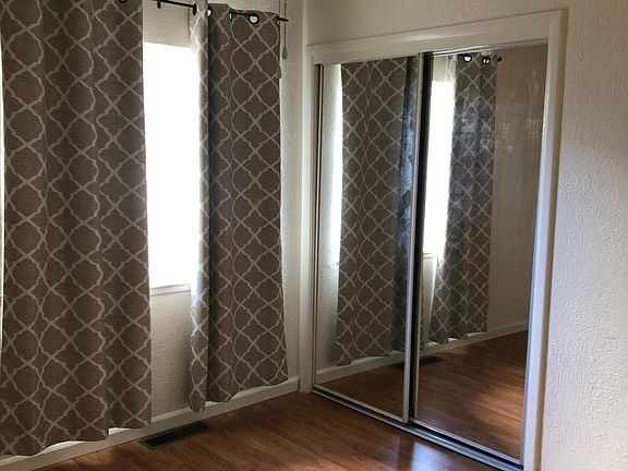 bedroom with ceiling fan/light and mirrored closet doors